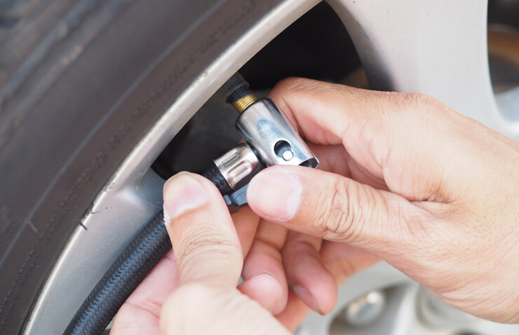 persona inflando neumáticos coche