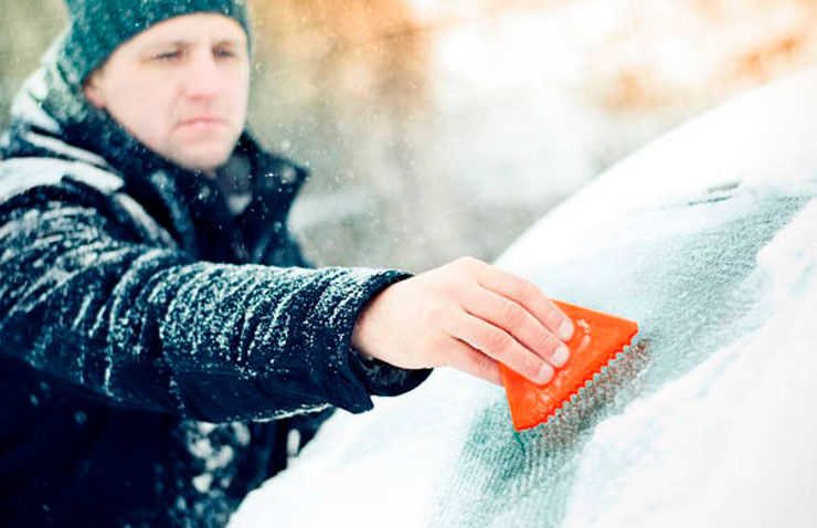 hombre quita hielo parabrisas