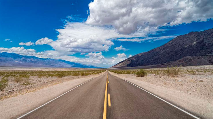 carretera larga y recta con las montañas de fondo